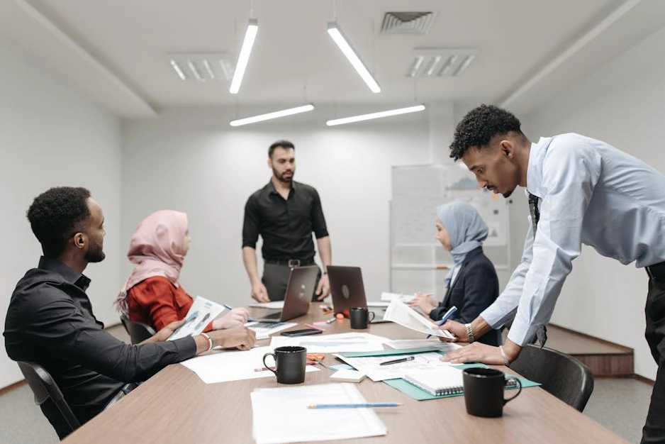 A diverse group of finance professionals collaborating in a bright, modern meeting room.